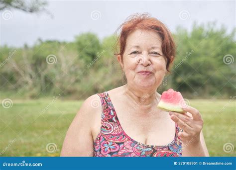 mature woman enjoying a slice of watermelon outdoors healthy refreshing food stock image