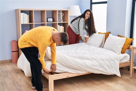 Man And Woman Couple Doing Chores Make Bed At Bedroom Stock Photo