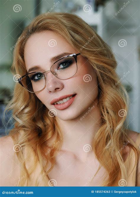 headshot of happy beautiful blonde woman in glasses with gorgeous trendy makeup beauty shiny