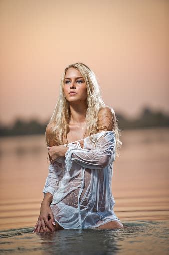 Sexy Blonde Woman With Wet Lingerie In River During Sunset Stock Photo