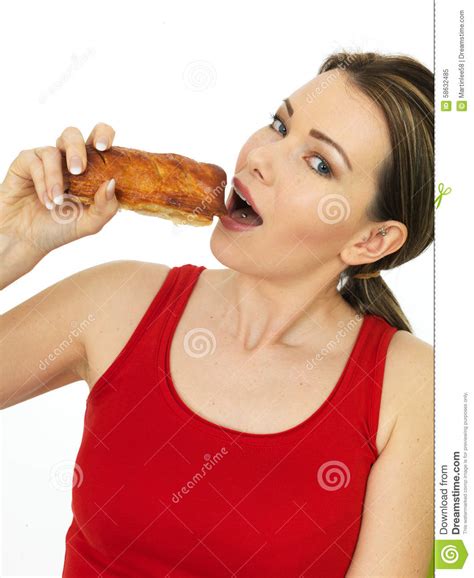 Attractive Young Woman Holding A Cooked Hot Savory Sausage Roll Stock