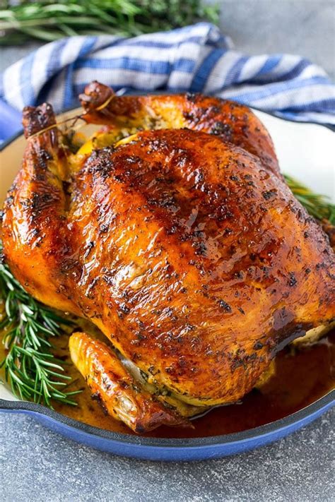 a roasted chicken in a pan garnished with fresh rosemary sprigs whole chicken recipes oven