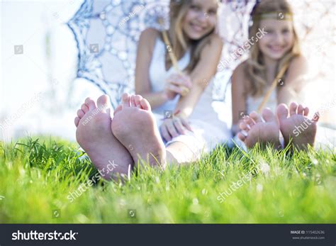 Two Girls Sitting On The Grass With Bare Feet Stock Photo Shutterstock