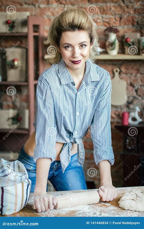 Young Woman Blonde Prepares Dough In The Kitchen Housewife With Bags