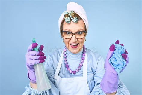 Portrait Of Happy Old Cleaning Woman In Apron With Dust Cleaning Brush Isolated On Blue