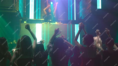 Grupo De Personas Bailan En Discoteca Al Ritmo De La Música De Dj En El Escenario Foto Premium