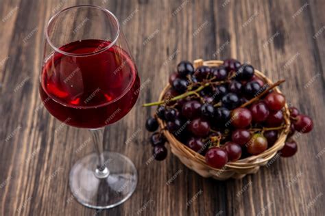Free Photo Side View Of Grape Juice In Wineglass And Basket Of Red