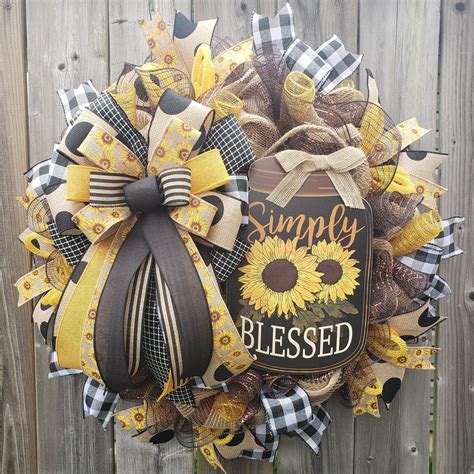 A Sunflower Wreath With The Words Simply Blessed On It And A Ribbon