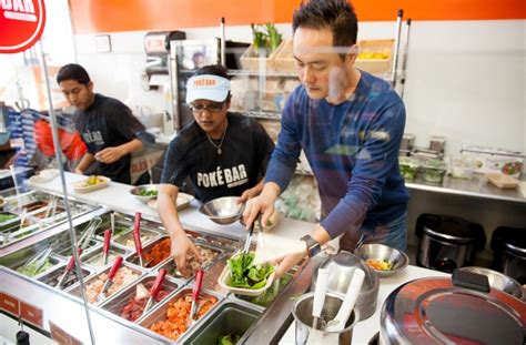 Our staff is following stringent sanitation. Chris Lim, right, owner of Poké Bar in Mountain View ...