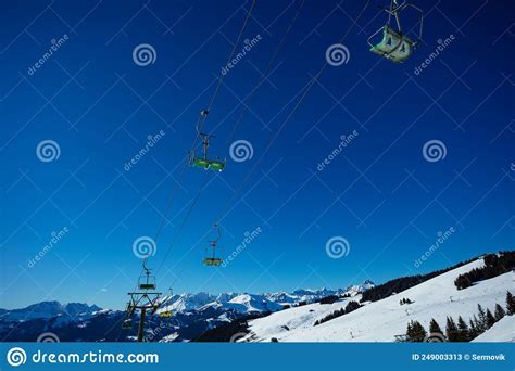 Ski Lift Seats Over Blue Sky And Mountain Range Summits Stock Image