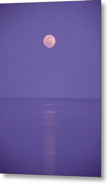 A Pink Full Moon Hangs Centered Over A Still Body Of Water In The