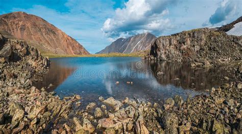 Panoramic View Of A Blue Clean Mountain Lake In The Altai With Tents On