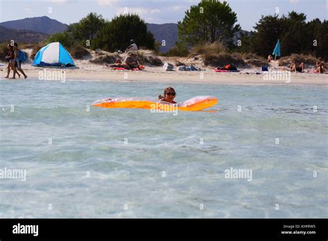 A Pretty Young Woman In Bikini Enjoying Sardinia Holiday In The Sea Water With A Lilo Raft