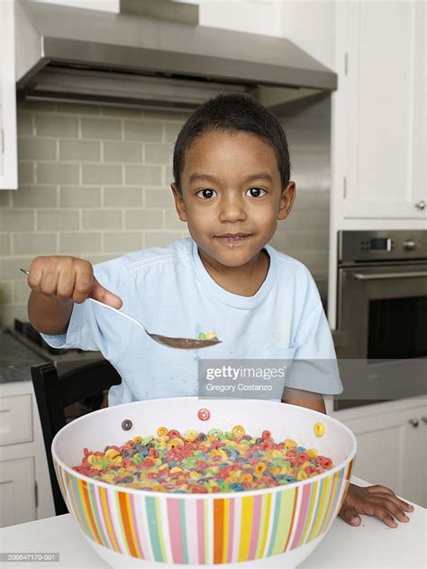 Boy Eating Breakfast Cereal From Large Bowl In Kitchen Portrait High