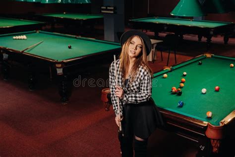 A Girl In A Hat In A Billiard Club With A Cue In Her Handsbilliards