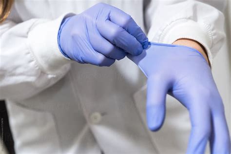 Scientist Female Putting The Gloves In The Lab By Stocksy Contributor