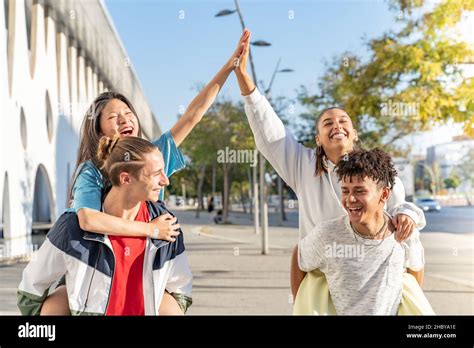 Multiethnic Group Of Young Happy Friends Walking Down The Street