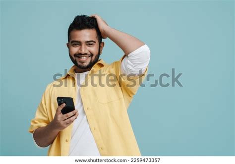Cheerful Indian Guy Yellow Shirt Using Stock Photo 2259473357
