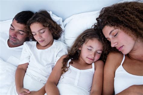 Familia Que Duerme Junto En Cama Foto De Archivo Imagen De Cerrado