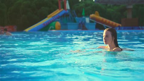 A Pretty And Young Girl Who Wears A Swimsuit Plunges Into The Water In The Pool In Order To