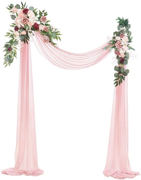 A Pink Wedding Arch Decorated With Flowers And Greenery