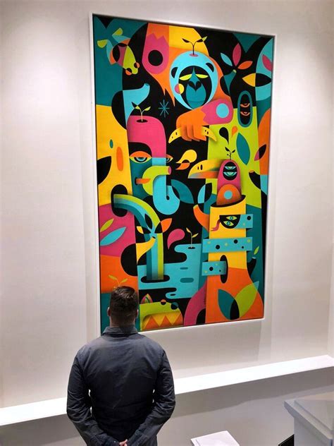 A Man Standing In Front Of A Colorful Painting On Display At An Art