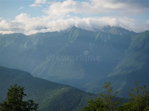 High Green Mountains With Snowy Peaks In The Clouds Stock Image Image