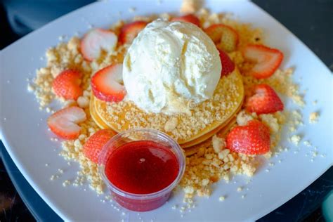 Pancake Served With Ice Cream And Strawberry Jam And Fresh Strawberries