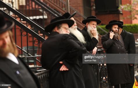 Hasidic Men Pause In A Jewish Orthodox Neighborhood In Brooklyn On