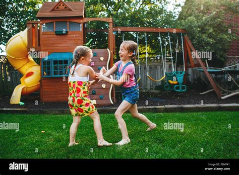 Portrait Of Two Little Girls Sisters Fighting On Home Backyard Friends