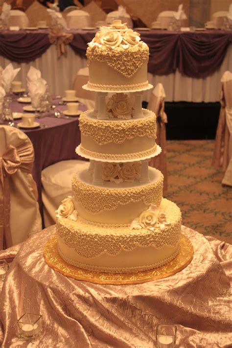 Traditional Ivory Wedding Cake With Columns And Buttercream Roses