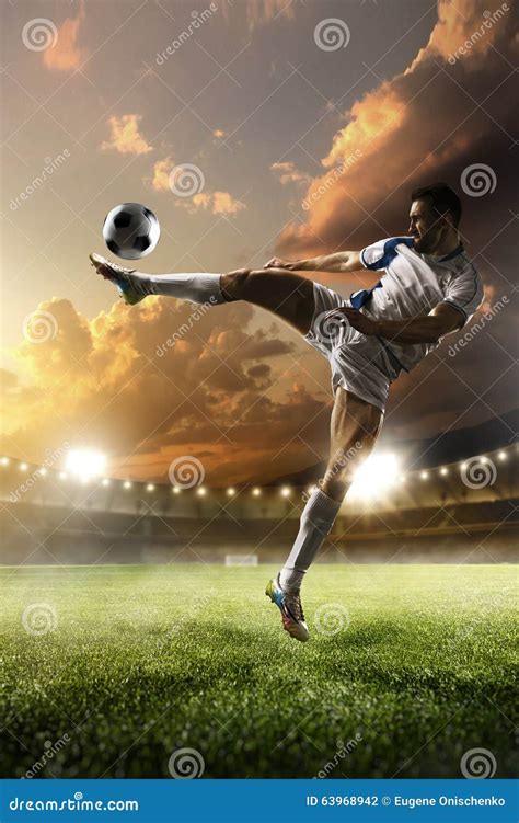 Soccer Player In Action On Sunset Stadium Background Stock Photo