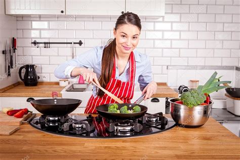 Young Woman Cooking In Kitchen Stock Photo By ©marekgalica 74013483