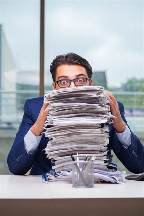 The Businessman With Pile Stack Of Paper Paperwork In The Office Stock