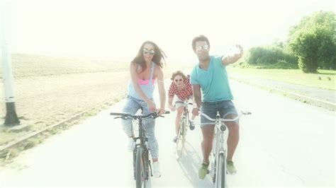 Close Up Of Three Young Adults Cycling Outdoors And Having Fun Taking Selfies Graded Warmer