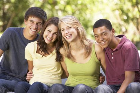 Quattro Amici Adolescenti Che Si Siedono Sul Trampolino In Giardino Fotografia Stock Immagine