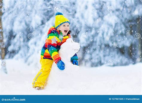 Child Making Snowman Kids Play In Snow In Winter Stock Image Image