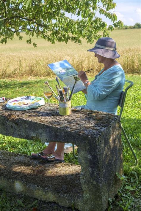 A Lady Artist Sits In Shade Working On A Painting Stock Image Image