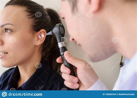 Lateral View Of A Male Otolaryngologist Examining The Ear Stock Photo