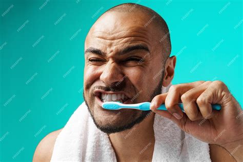 Premium Photo Cheerful Dark Skinned Male Brushing His Teeth On Turquoise