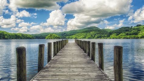 Wood Dock On Lake Pier And Landscape View Of Greenery Mountains Under