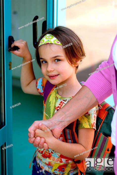 6 Years Old Girl In Front Of School Door With Her Mother Stock Photo