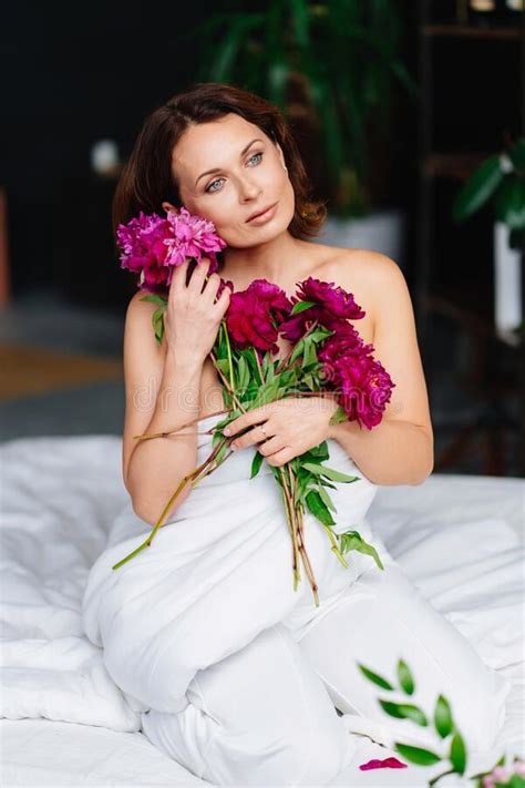 Gentle Topless Woman With A Bouquet Of Peonies In A Blanket On The Bed