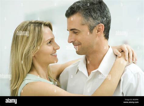 Couple Smiling At Each Other Woman Wrapping Arms Around Man Stock