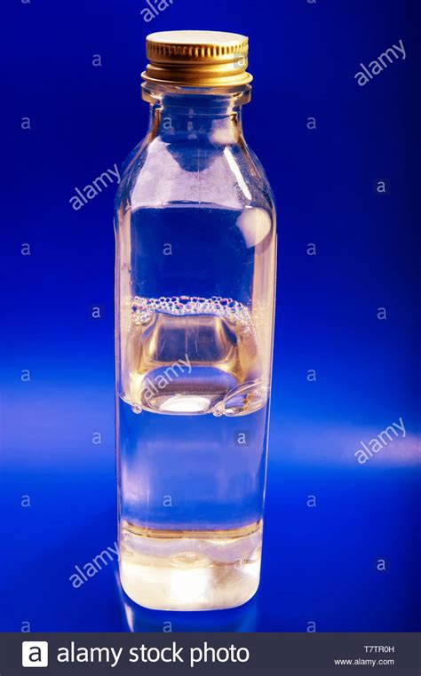 Bottle With A Clear Liquid On A Blue Background Stock Photo Alamy