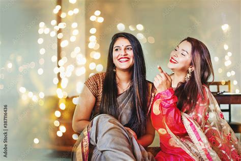 beautiful indian women in festive outfit posing as best friends laughing over a nice bokeh