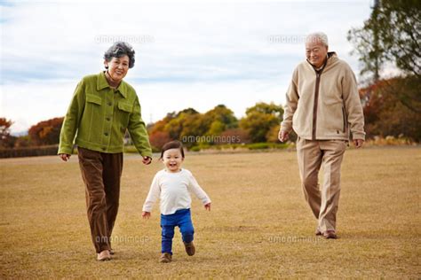 芝生の上でおじいちゃんとおばあちゃんと散歩する孫 10132105514 の写真素材・イラスト素材｜アマナイメージズ