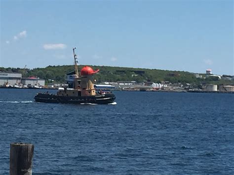 A Tug Boat In The Water Near A Dock