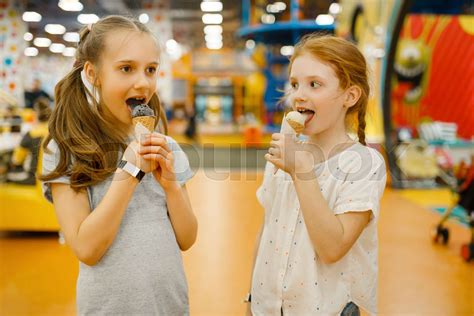 two girls eats ice cream in entertainment center stock image colourbox