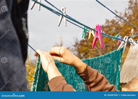 laundry woman hangs clean wet cloth on clothes dryer after washing at home household chores and